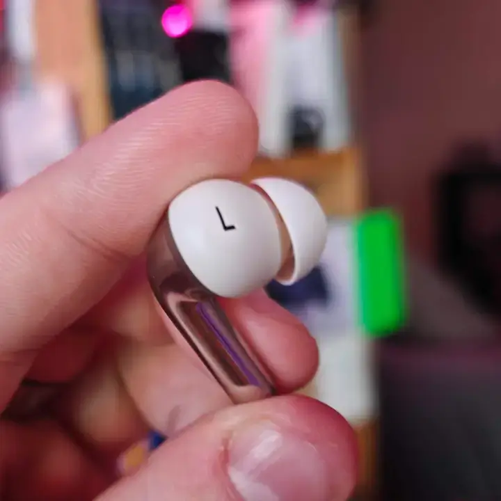 Close-up view of the OnePlus Buds Pro 3 earbuds showing the dual-driver setup and silicone ear tips.